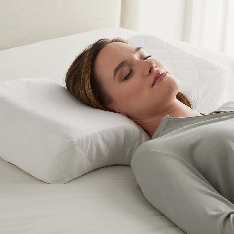 Back sleeper using a contoured ergonomic pillow