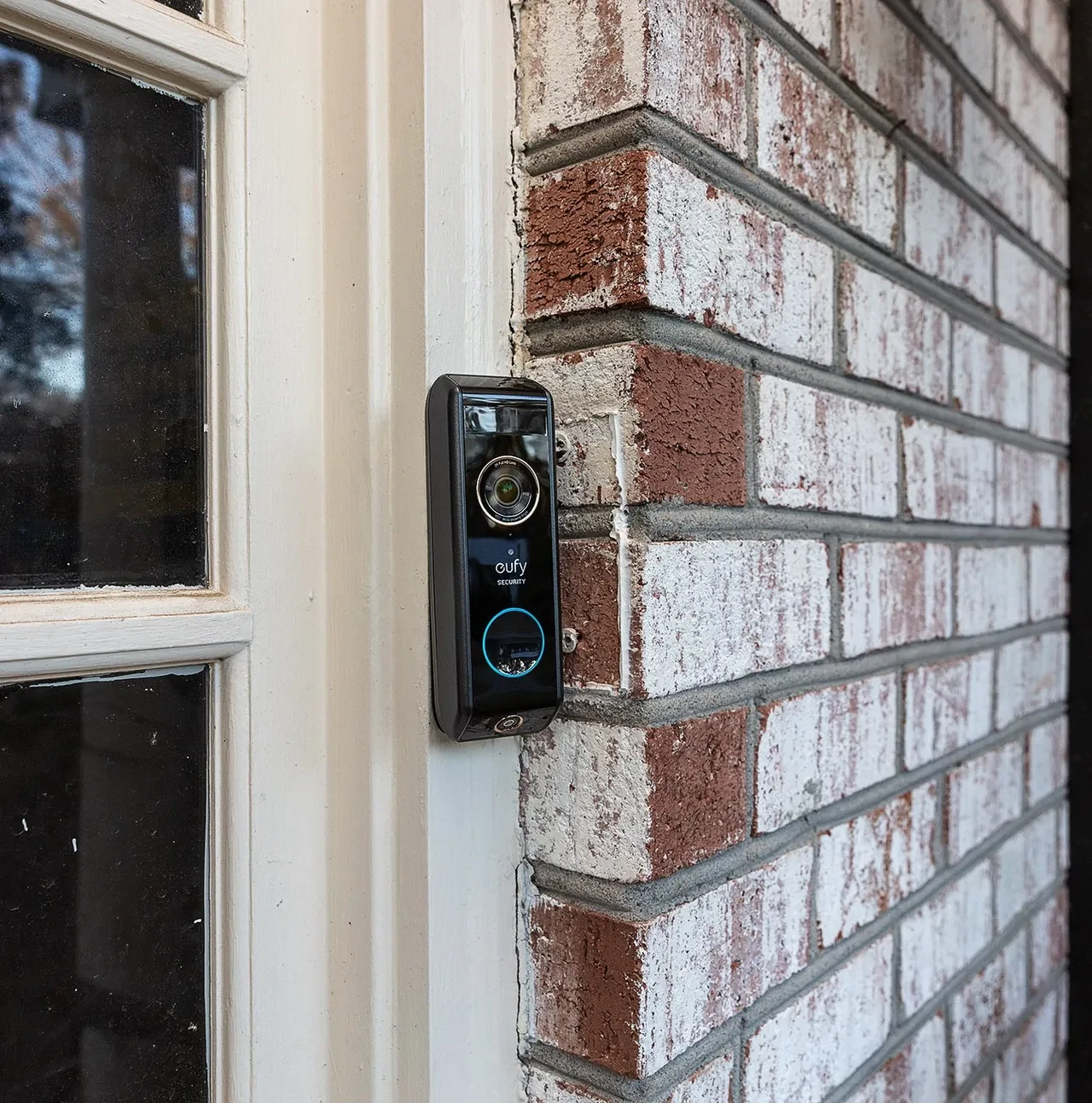 eufy Security video doorbell with glowing blue ring on a white door frame
