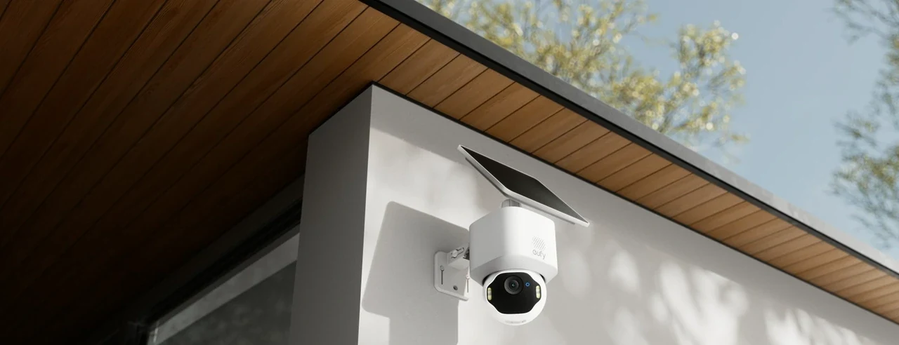 eufy outdoor pan-tilt camera with solar panel mounted under wooden eaves