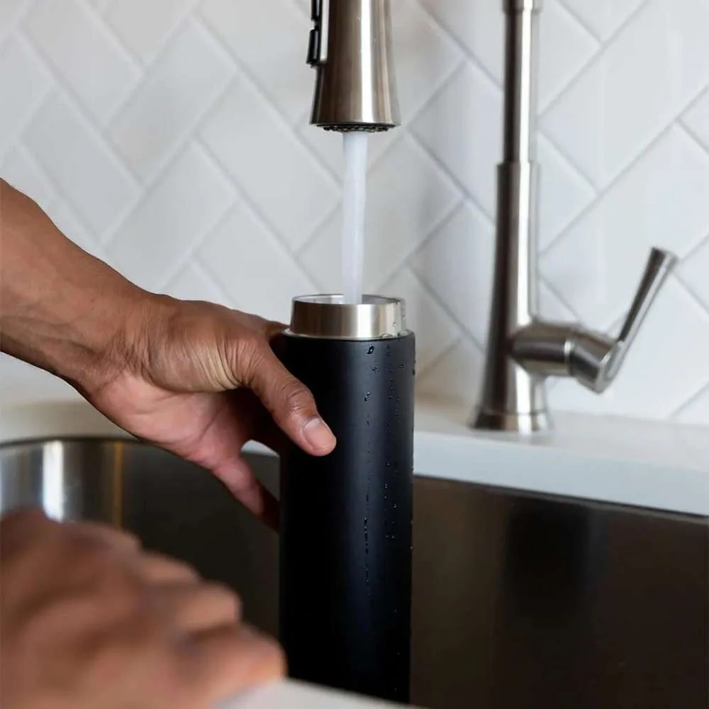 Filling a black UV water bottle under a kitchen faucet