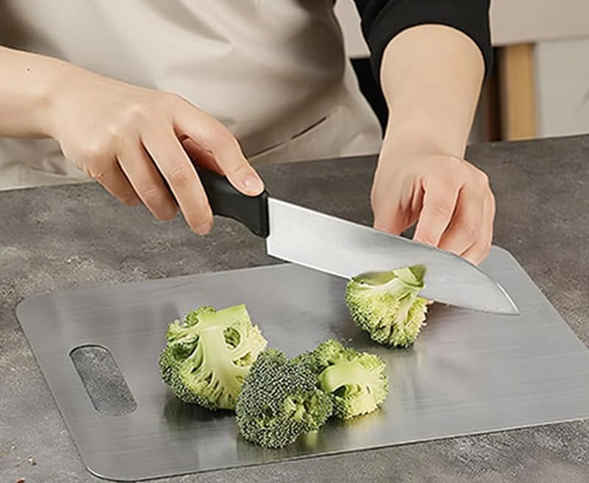 Chopping broccoli on a Katori titanium cutting board in the kitchen