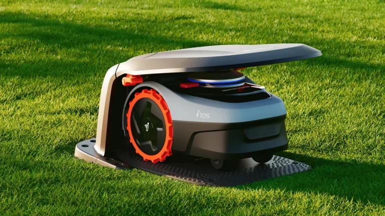 Segway Navimow i105 robot mower docked at its charging station on a green lawn