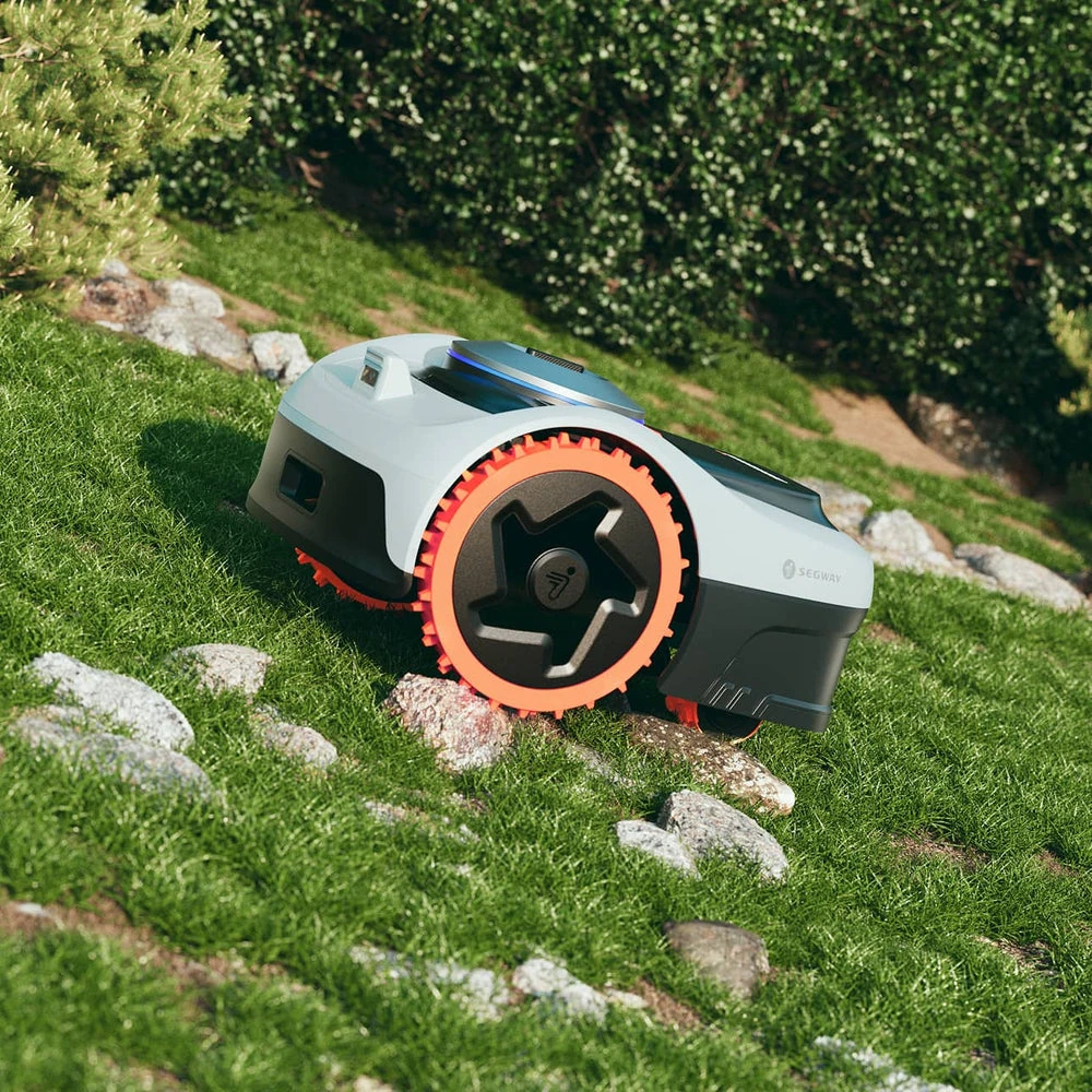 Segway Navimow climbing a rocky grassy slope