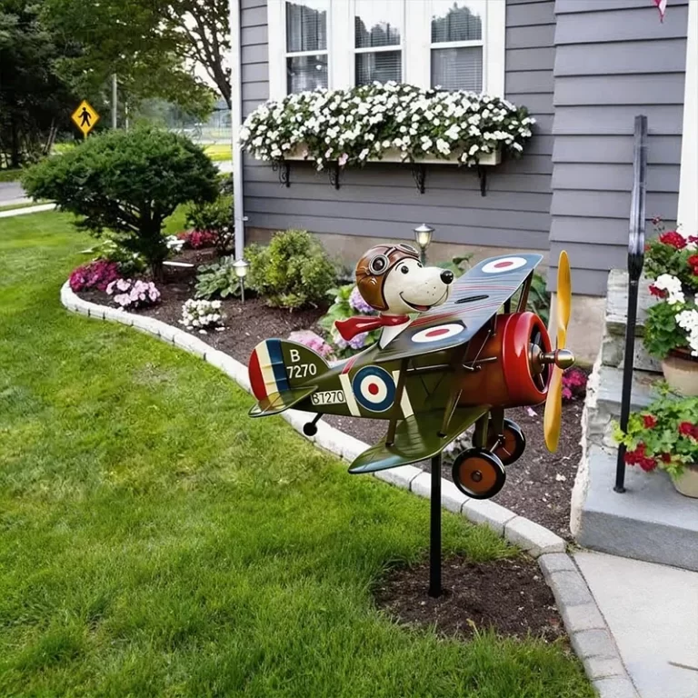 Windodream Sky Dreamer biplane garden windmill in a front-yard flower bed